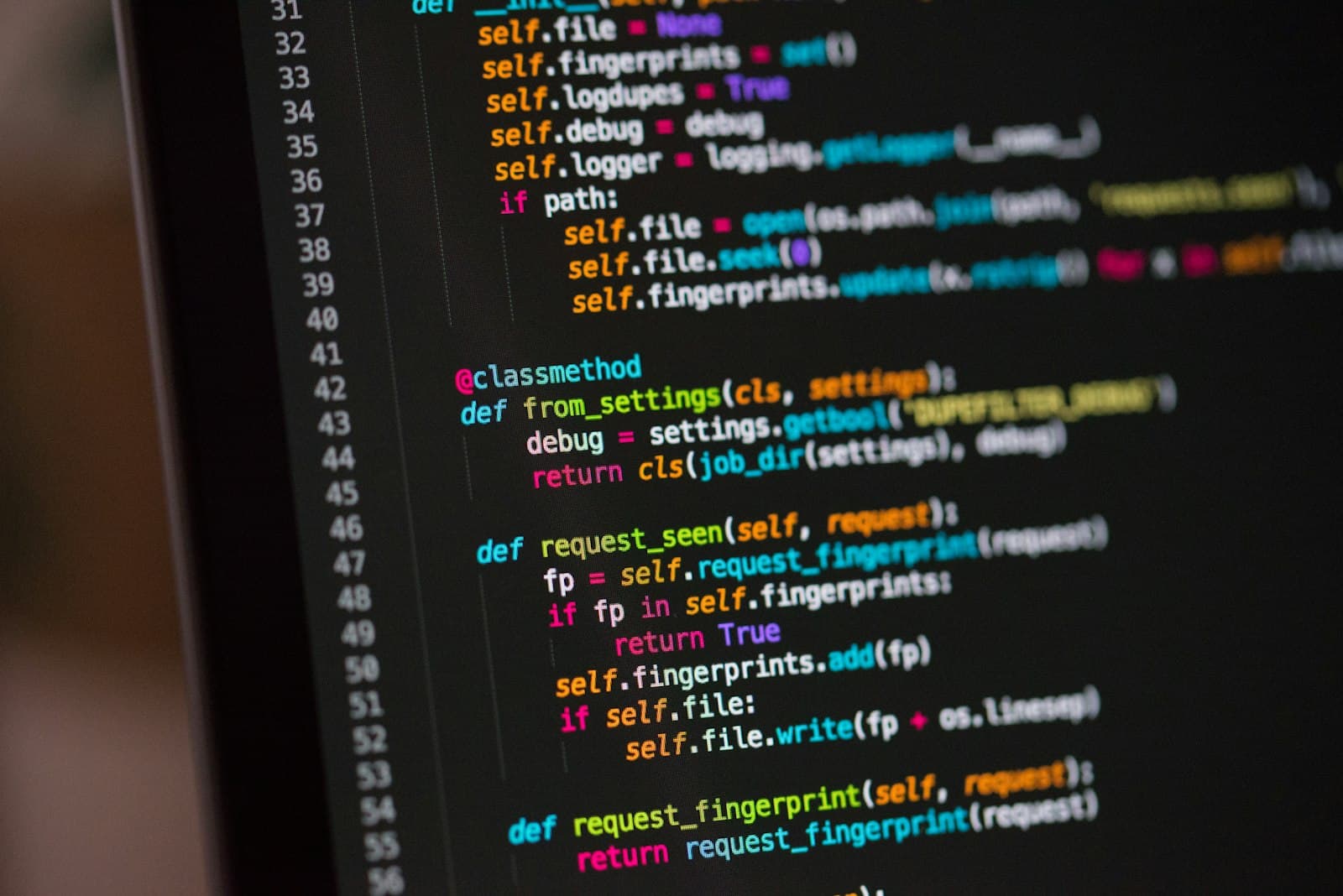 Developer workspace with code on screen and warm desk lighting