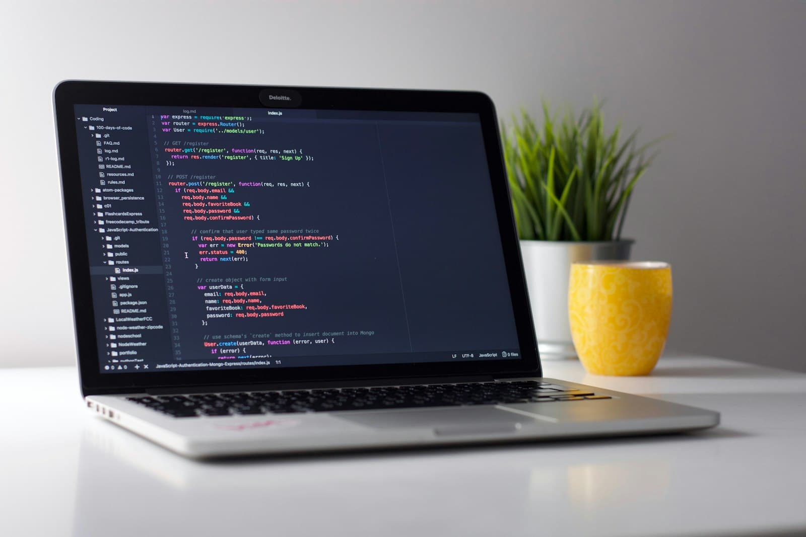 Laptop screen showing source code in a dimly lit workspace