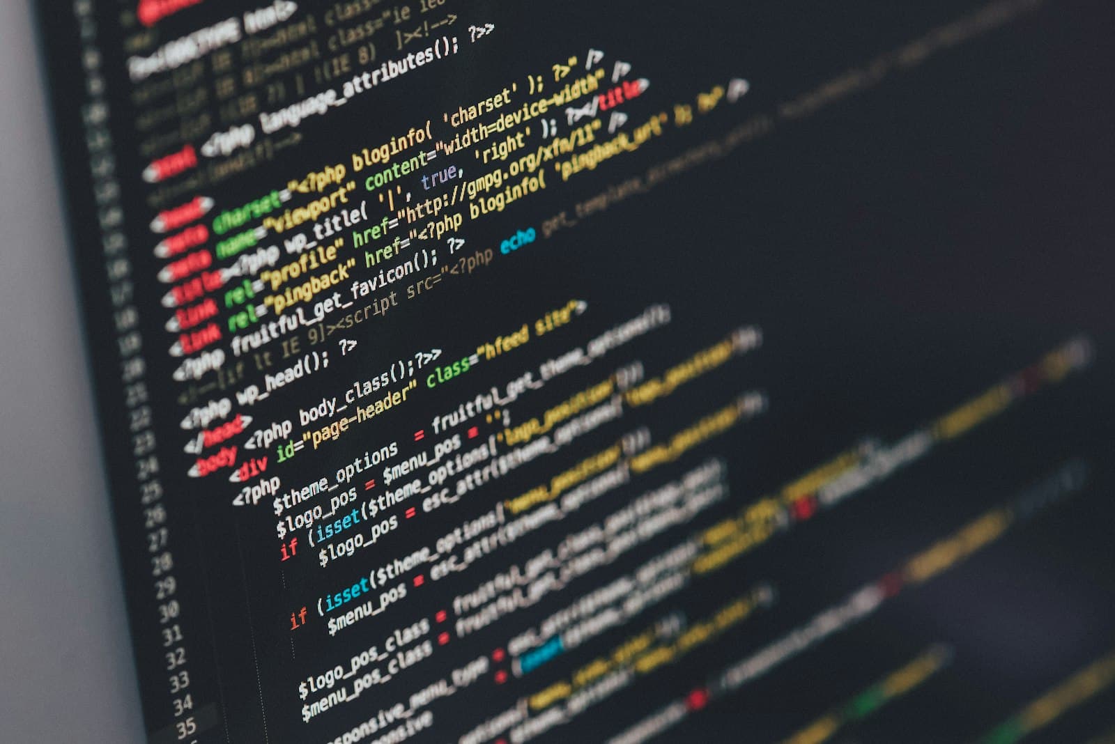 Laptop screen showing code in a dim workspace